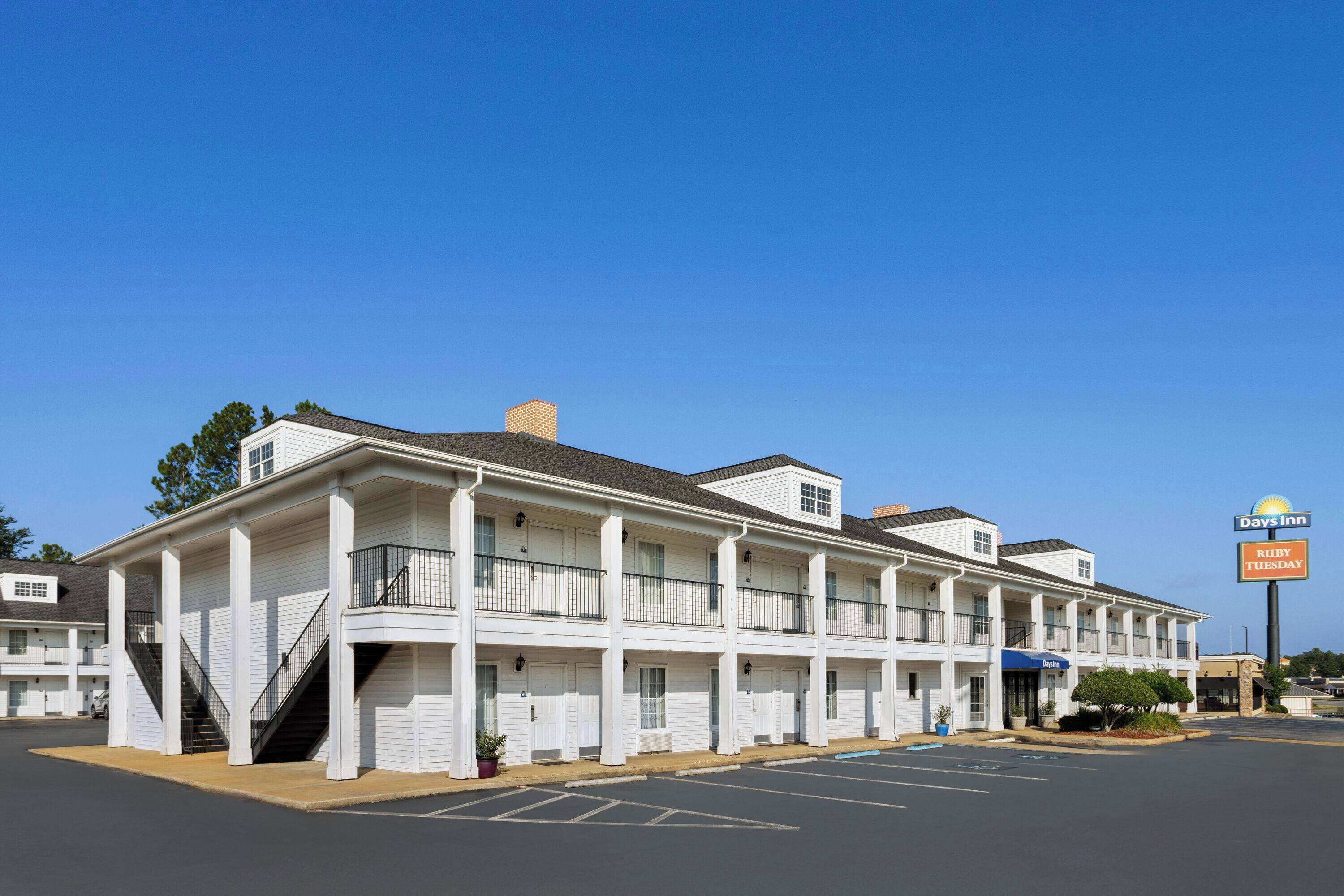 A motel with a central corridor, individual rooms on either side, and a Days Inn sign.