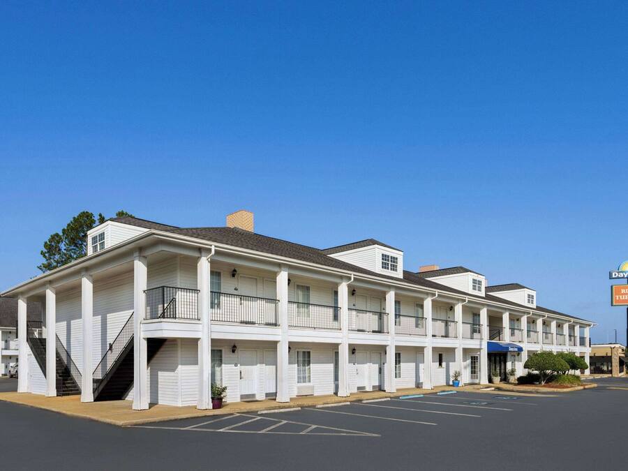 A motel with a central corridor, individual rooms on either side, and a Days Inn sign.