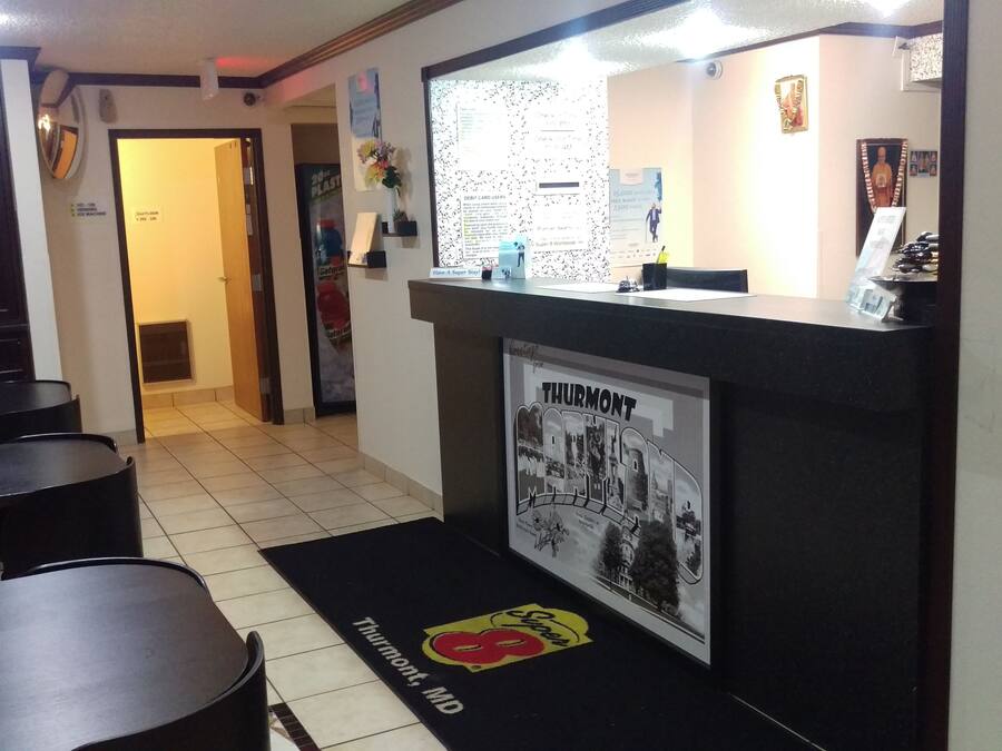 Vestíbulo de hotel con mostrador de recepción, un cubo de basura y un cartel de Thurmont, MD.