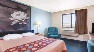 Una habitación de hotel con una cama, un escritorio, una silla, una ventana y un cuadro en la pared.