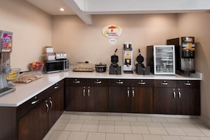 Ein Frühstücksbereich mit Mikrowelle, Toaster, Kaffeemaschine und Kühlschrank.