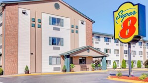 A Super 8 hotel with a brick facade, a covered entrance, and a parking lot. - Super 8 by Wyndham Louisville Airport (Louisville)