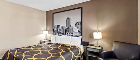 Una habitación de hotel con cama, una silla, un escritorio y un cuadro de paisaje urbano en la pared.