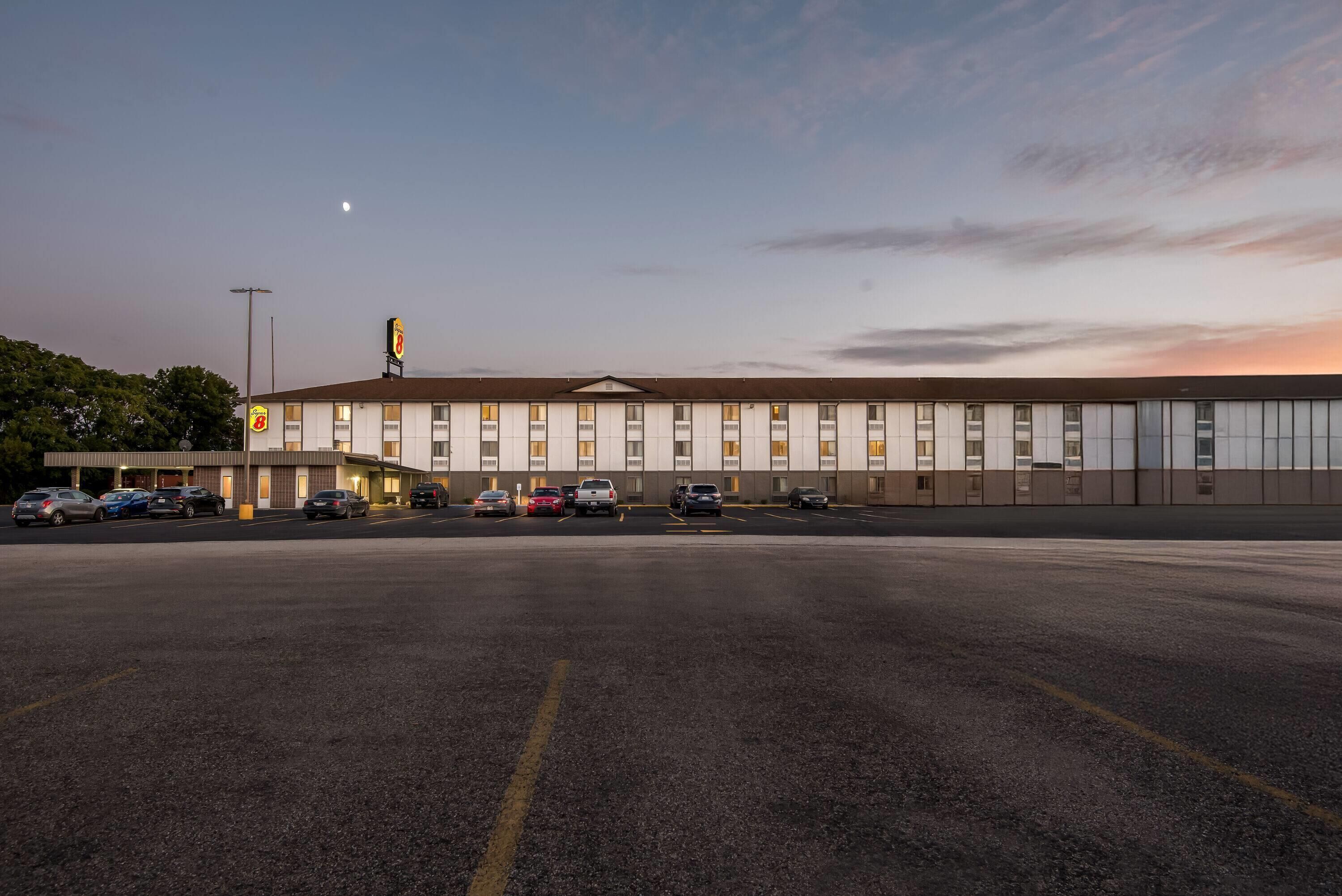 A large, modern building with a parking lot in front.