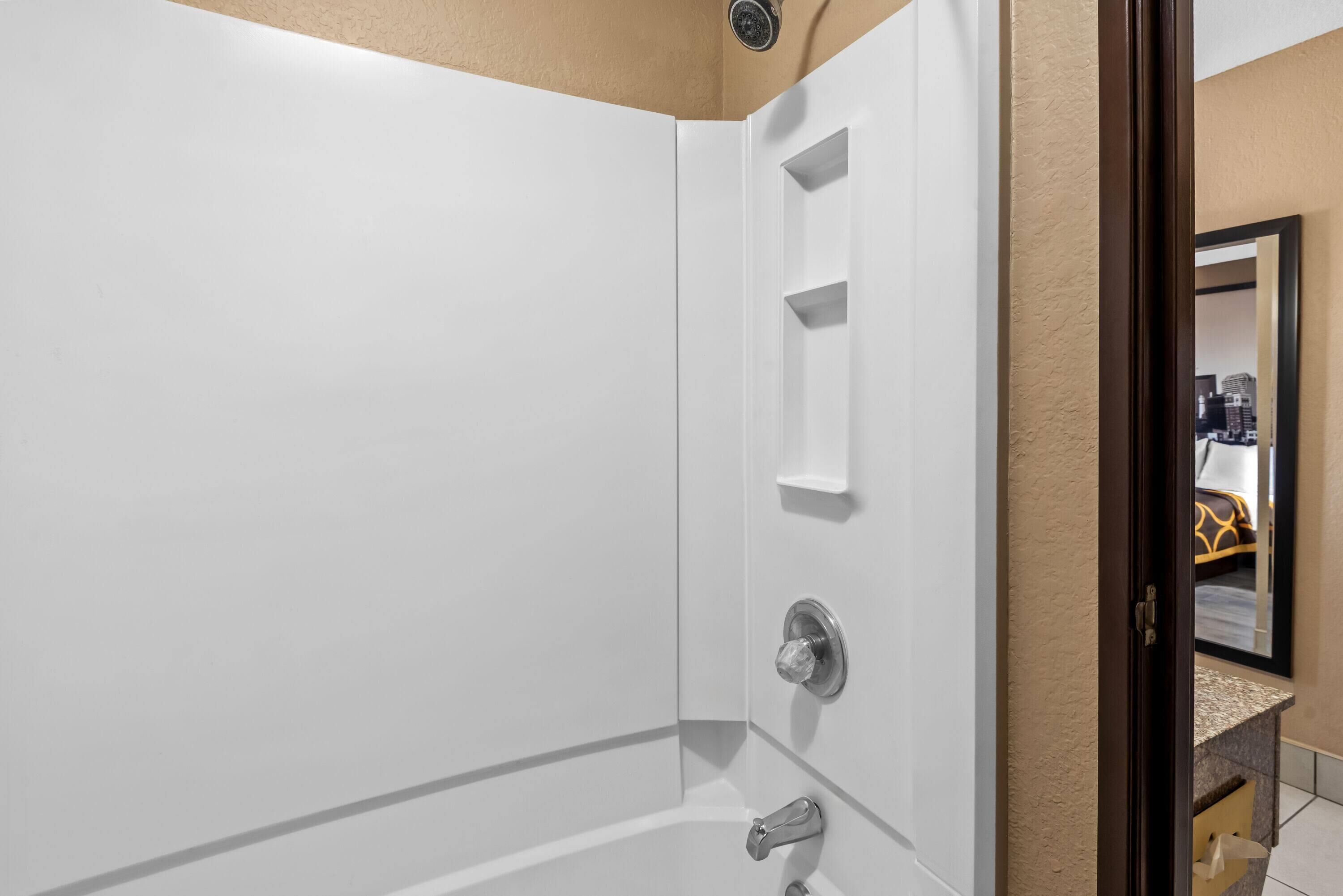 Un baño moderno con una bañera blanca, una zona de ducha y un lavabo con espejo.