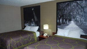 A hotel room with two beds, a nightstand with a lamp, and two large framed pictures on the wall. - Super 8 by Wyndham Warner Robins (Warner Robins)