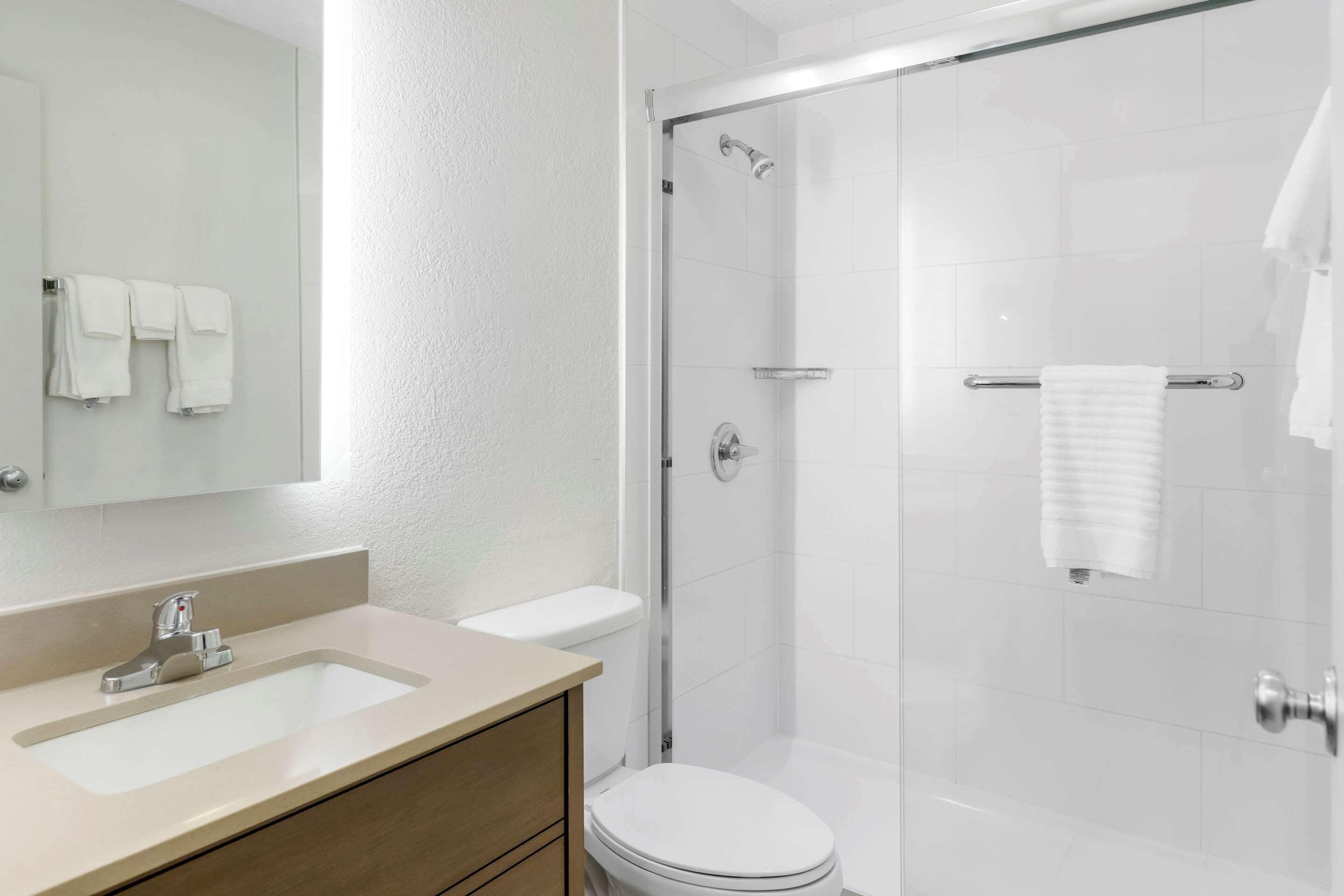 Ein modernes Badezimmer mit Waschbecken, Toilette und einer Duschkabine.