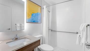 Un baño moderno con lavamanos, inodoro y ducha.