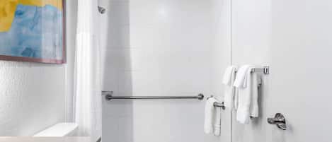 Uma casa de banho moderna com chuveiro, sanita e lavatório.