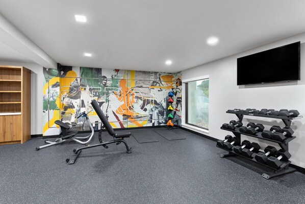 A gym with exercise equipment, a wall-mounted TV, and a window with a view. - La Quinta Inn & Suites by Wyndham Springdale (Springdale)