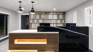 Una moderna recepción con panel de madera y encimera de mármol negro.
