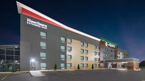 Un hotel Hawthorn Extended Stay con diseño moderno, que cuenta con un amplio estacionamiento y una entrada visible.