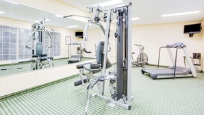 A gym with exercise equipment, a treadmill, and a mirrored wall. - Baymont by Wyndham Ozark (Ozark)