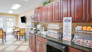 A breakfast area with wooden cabinets, a buffet setup, and a sign reading "Breakfast Corner". - Baymont by Wyndham Ozark (Ozark)
