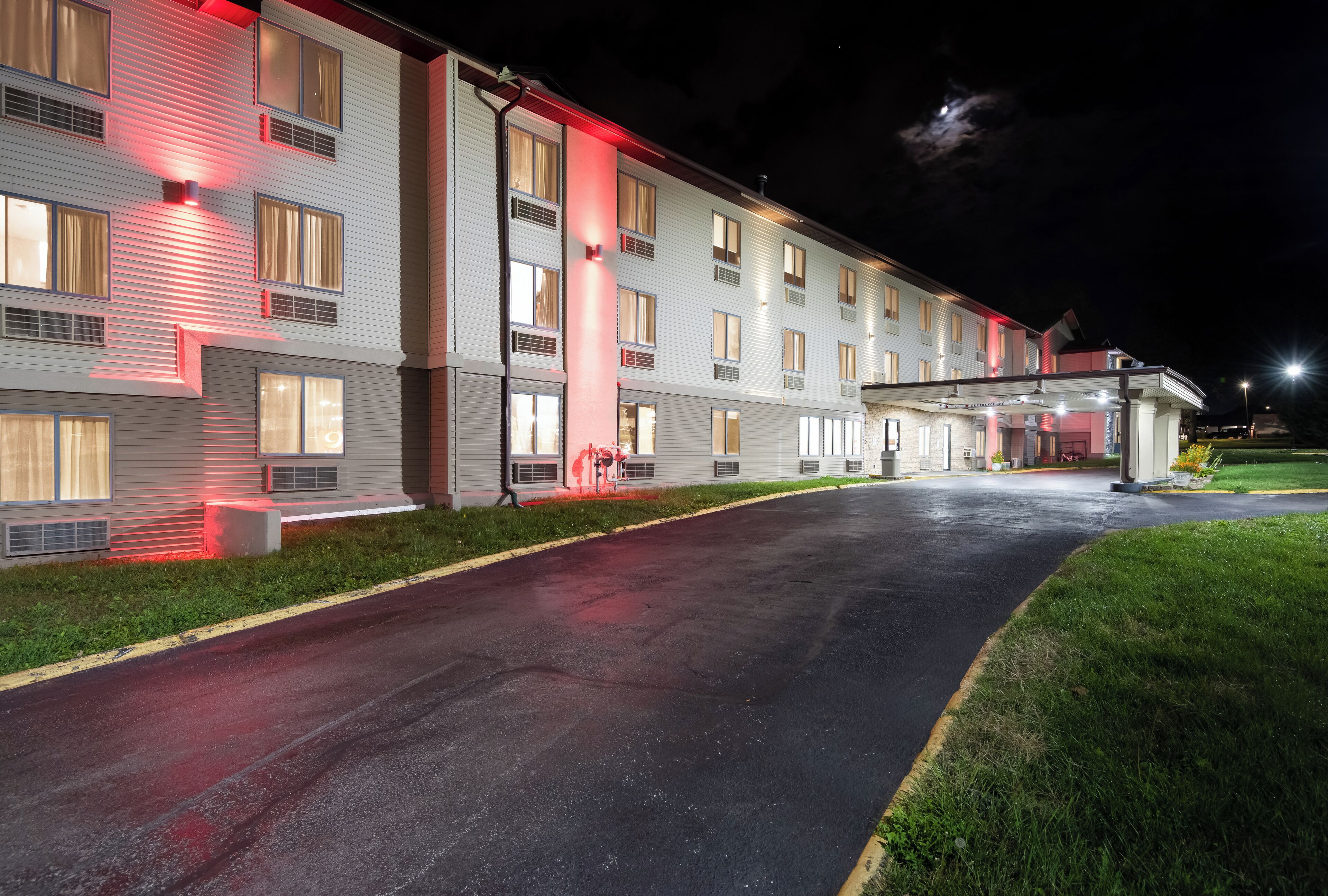 A multi-story hotel with a covered entrance and a parking lot.