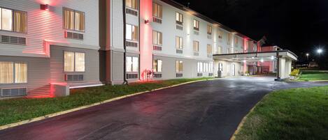 A multi-story hotel with a covered entrance and a parking lot.