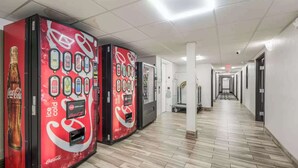A hallway with vending machines and a clean, tiled floor. - Sonesta Essential Des Moines (Des Moines)