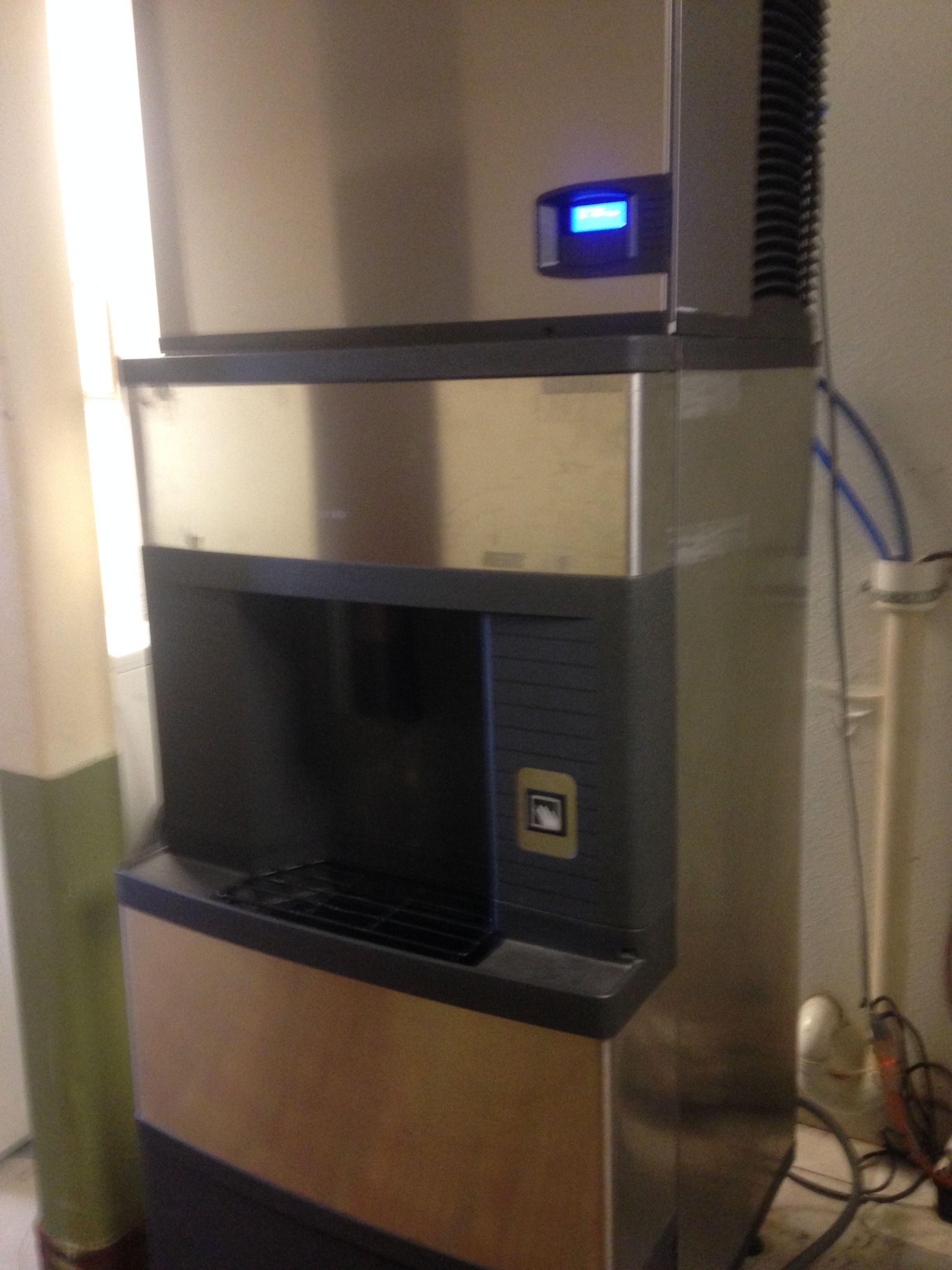 A stainless steel water dispenser with a digital display, a water filter, and a control panel.