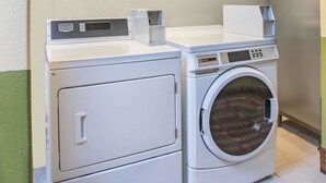 A front-loading washing machine with a control panel and a dryer stacked on top. - Super 8 by Wyndham Craig (Craig)