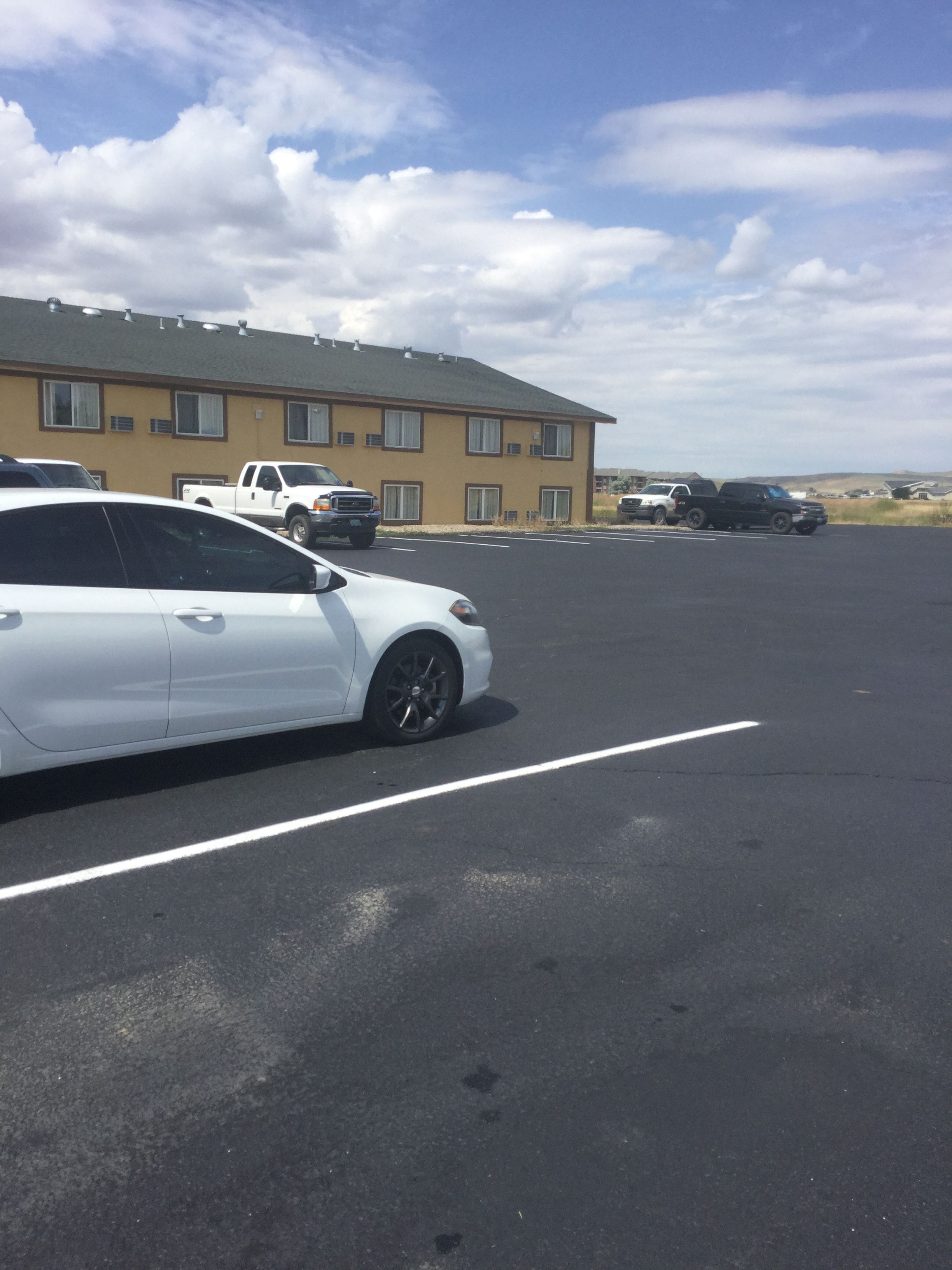 A parking lot with a white car parked in the foreground.