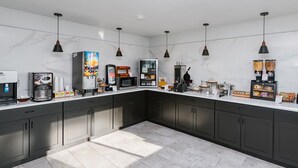 A modern kitchen with a marble backsplash, stainless steel appliances, and pendant lighting.