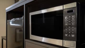 Un horno microondas con panel de control digital, integrado en un mueble.
