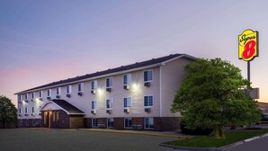 A Super 8 hotel with a brick facade, multiple windows, and a large sign. - Super 8 by Wyndham Clinton (Clinton)