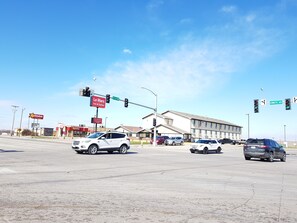 A multi-story building with a flat roof and a large parking lot. - Le Mars Inn & Suites (Le Mars)