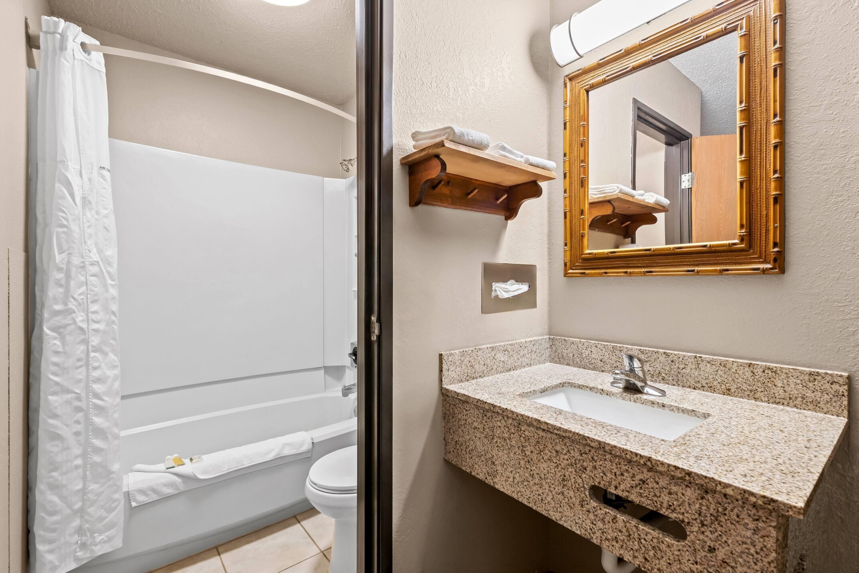A bathroom with a shower, toilet, and sink.