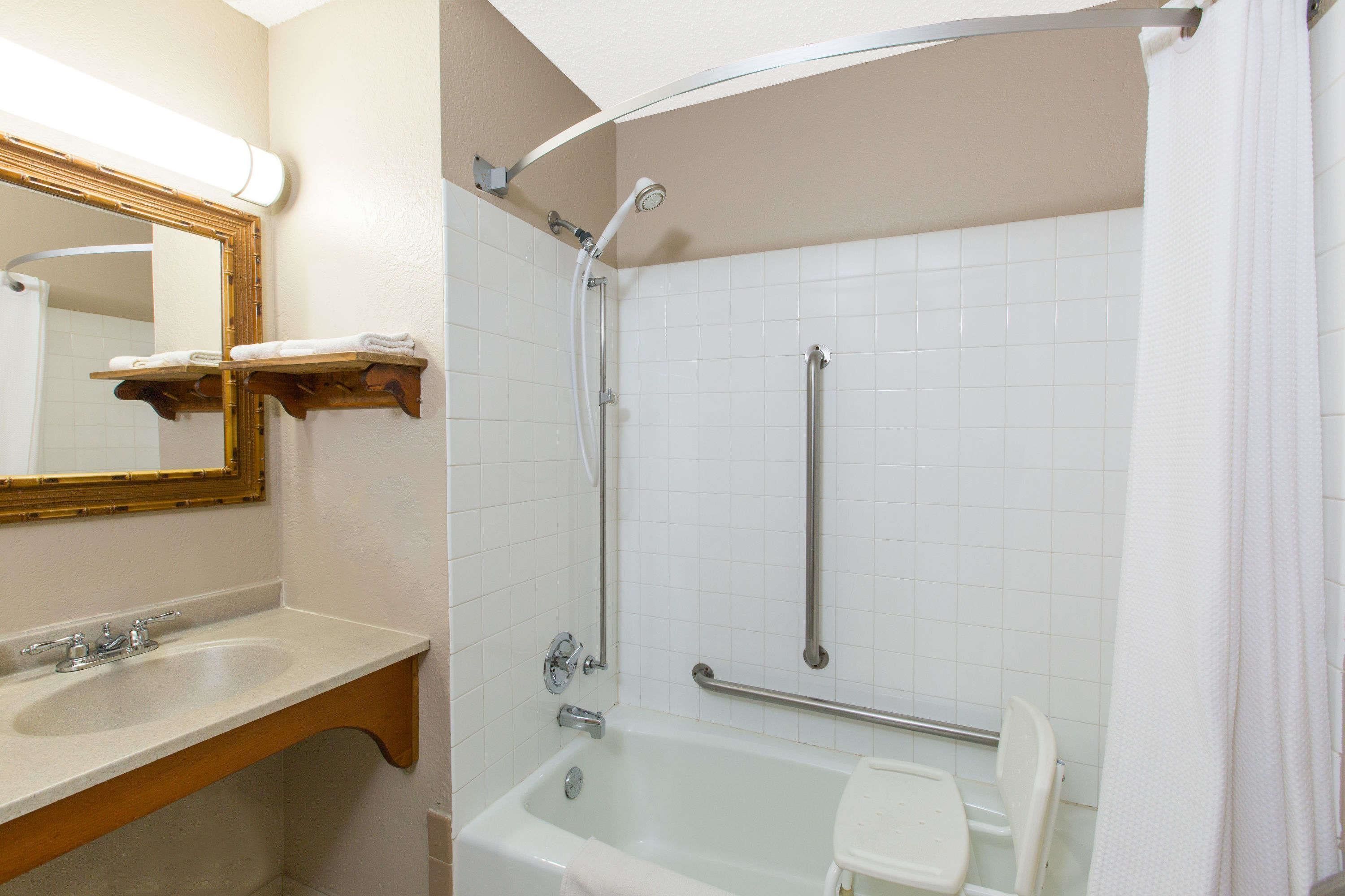 Ein Badezimmer mit Waschbecken, Spiegel und Badewanne.