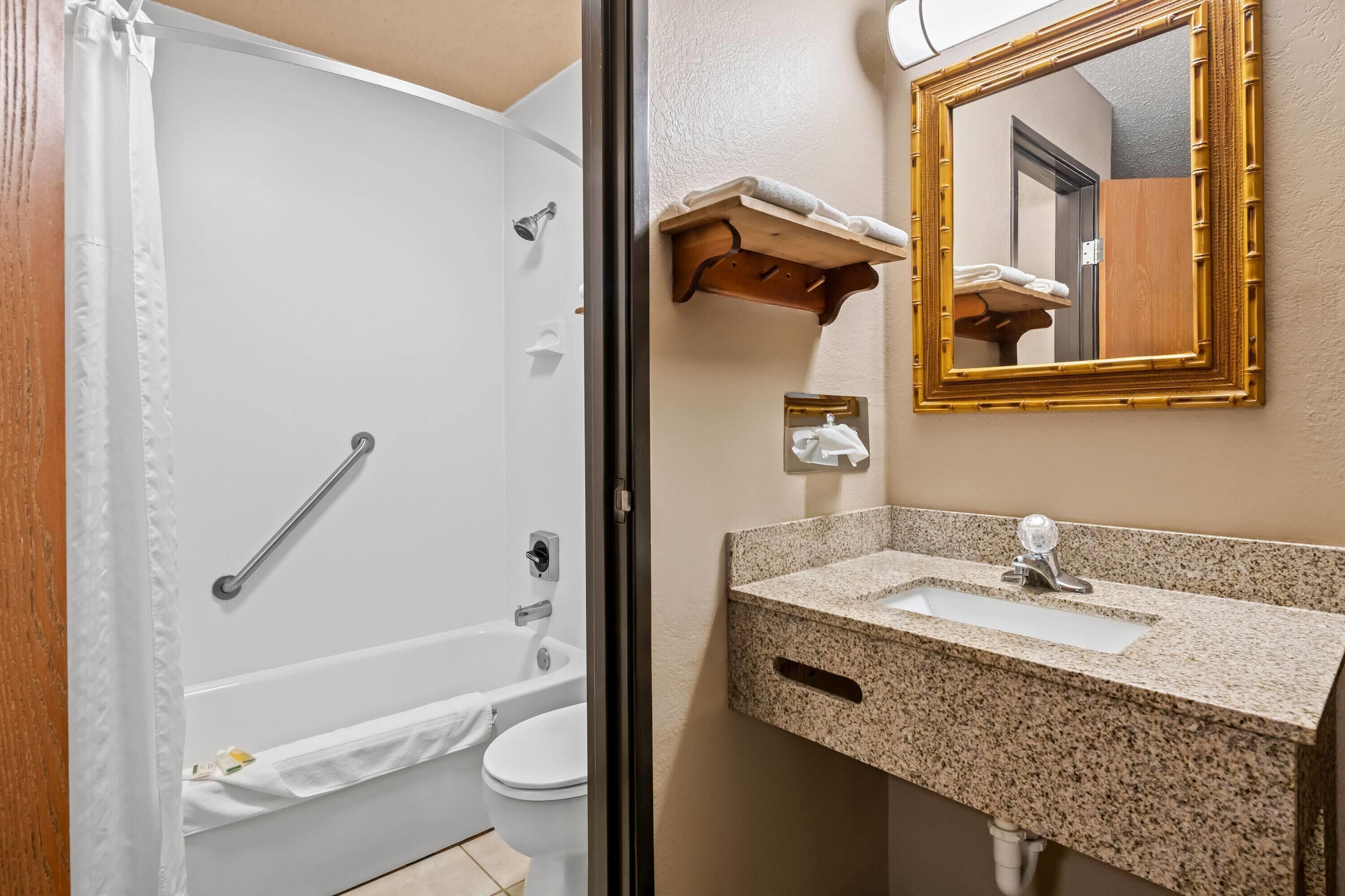 Un baño con bañera, inodoro y lavamanos.