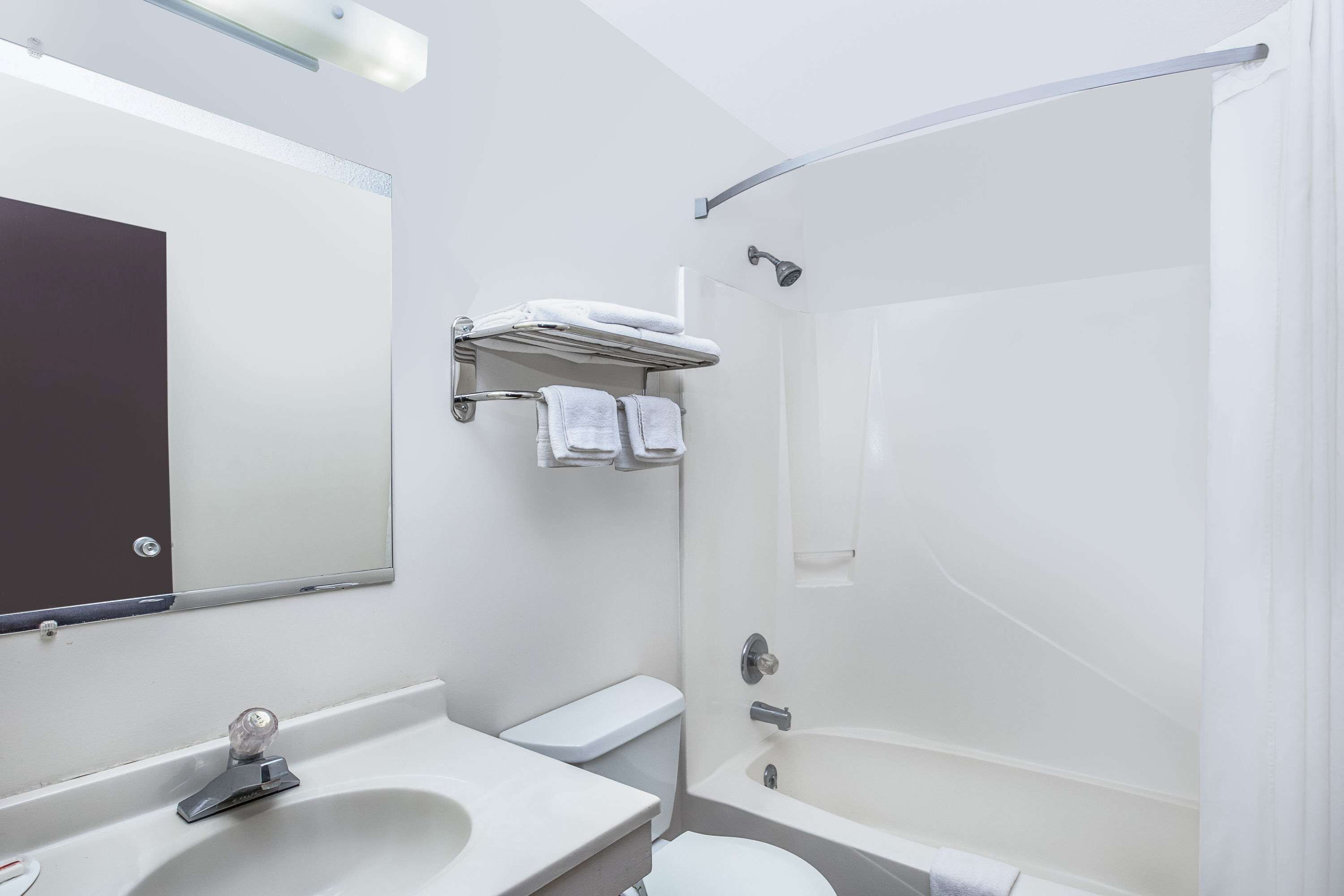 A modern bathroom with a white sink, toilet, and shower.