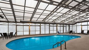 An indoor swimming pool with clear glass walls, metal beams, and a concrete floor. - La Quinta Inn & Suites by Wyndham Chicago Tinley Park (Tinley Park)