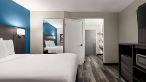 A hotel room with a large bed, a desk, and a wardrobe. - La Quinta Inn & Suites by Wyndham Chicago Tinley Park (Tinley Park)