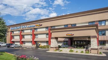 Situated in a parking lot, this hotel features a modern design with a flat roof and windows on each floor, marked by a prominent entrance and landscaped areas.