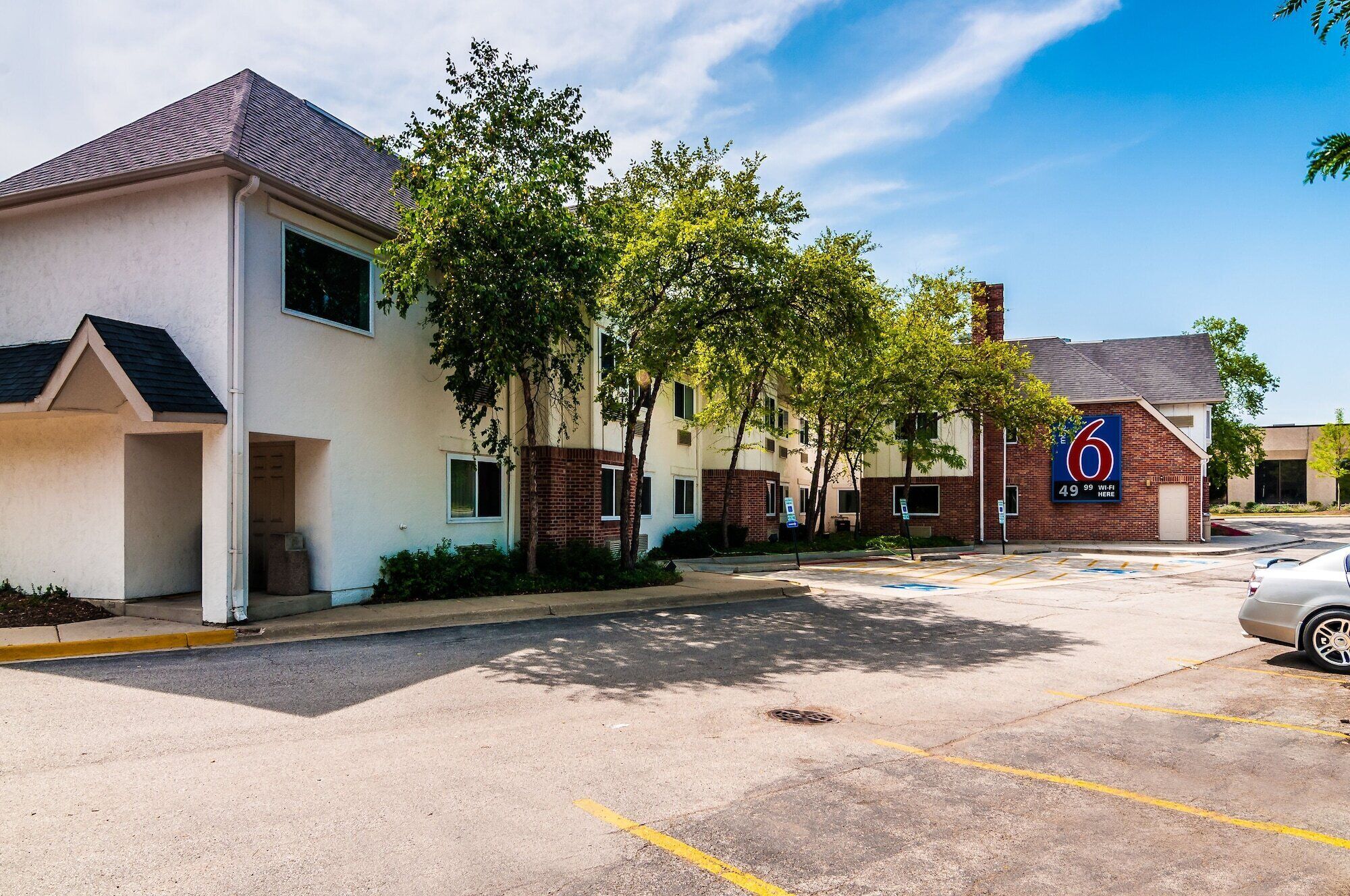A parking lot with a building labeled '6' and a sign indicating '49 99 WiFi here'.