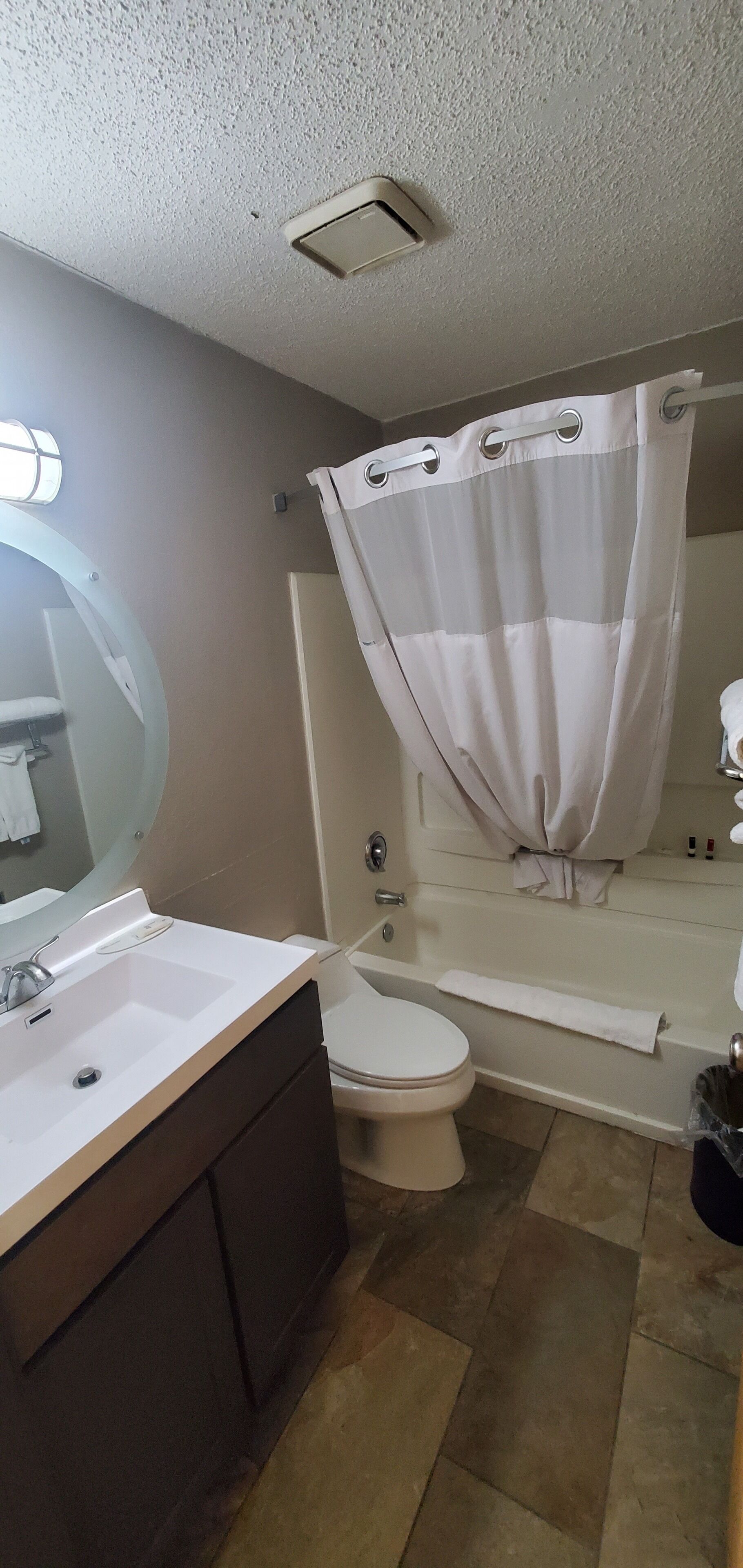 A bathroom with a sink, toilet, and shower curtain.