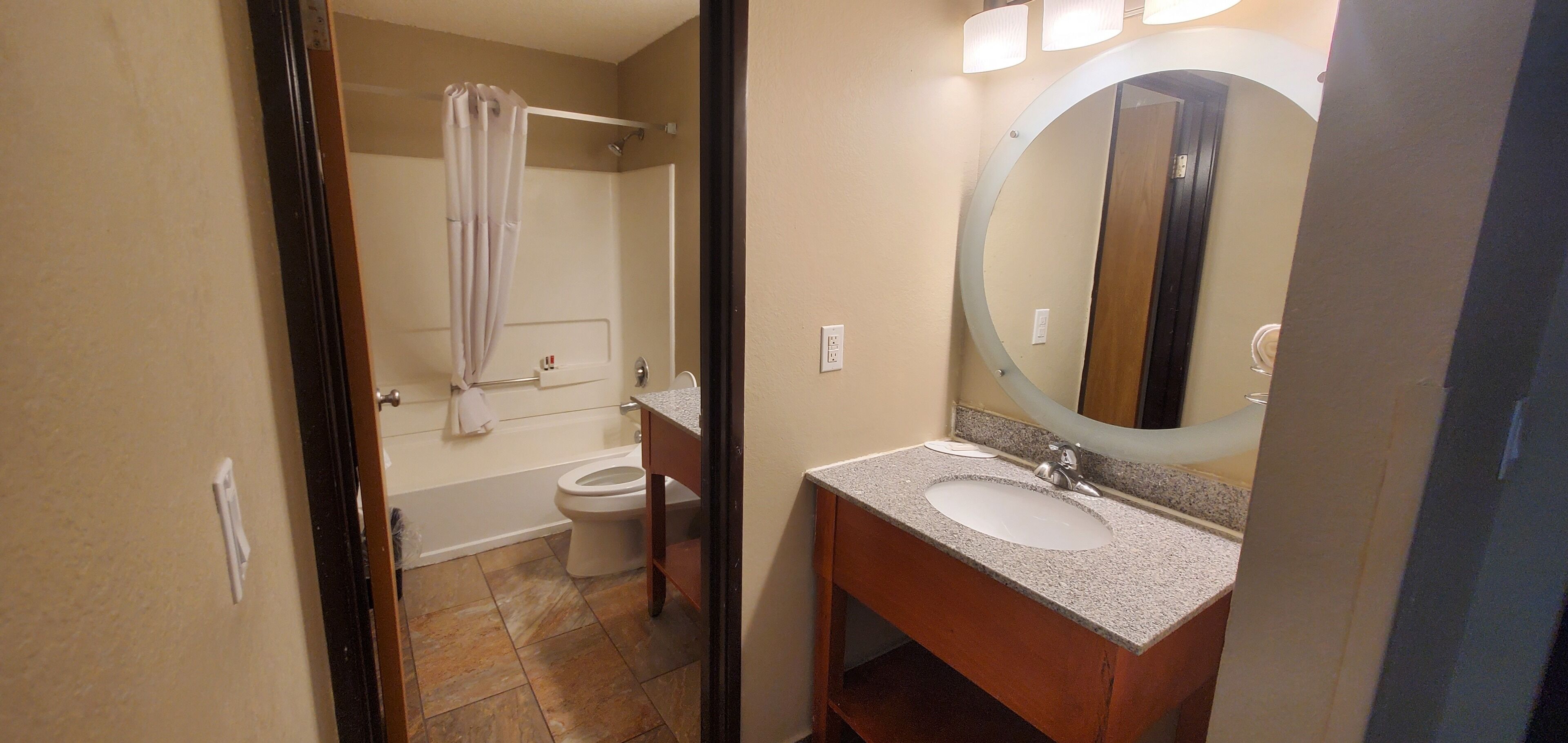 A bathroom with a sink, mirror, and toilet.
