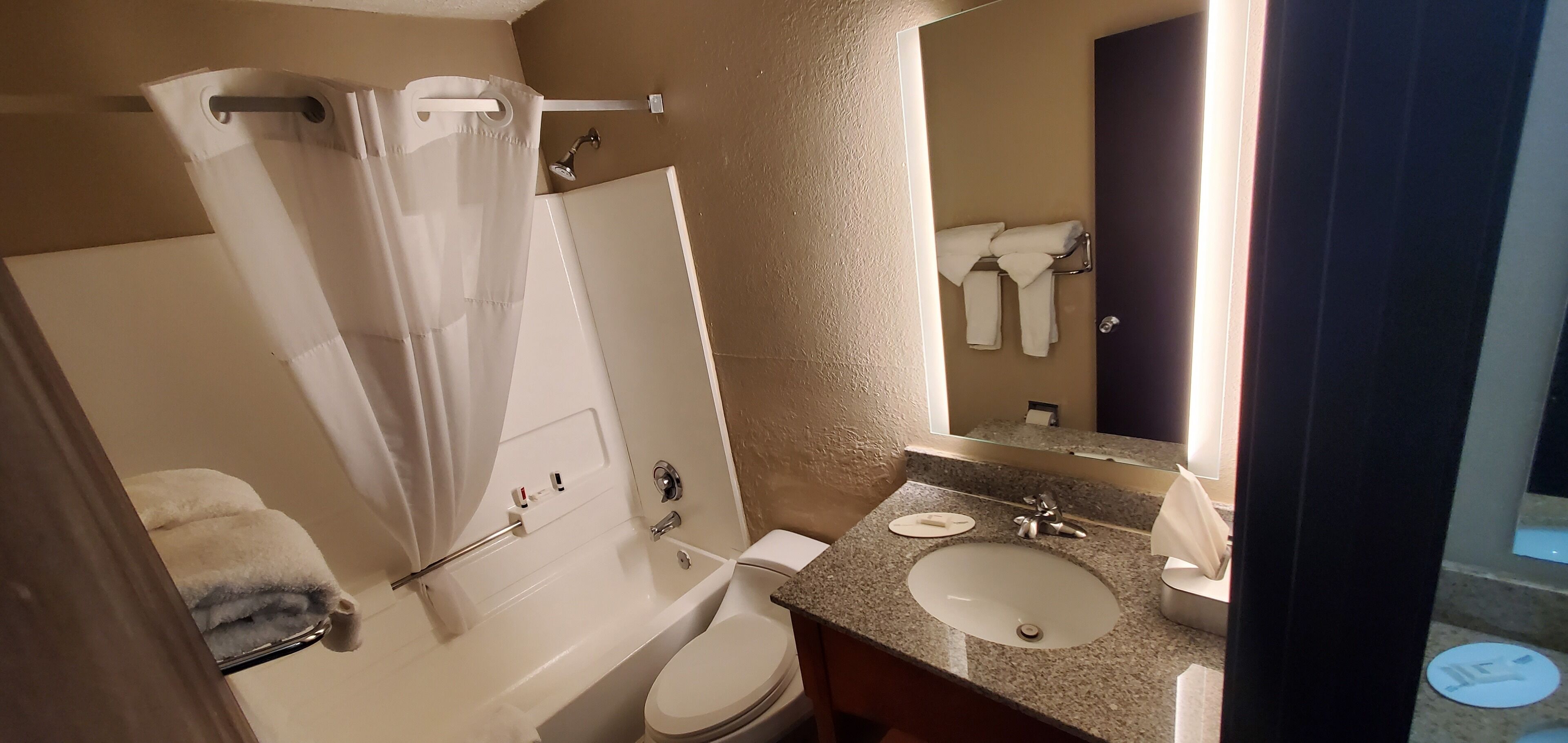 Un baño con bañera, inodoro, lavabo y espejo.
