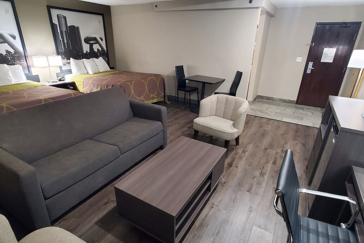 Ett hotellrum med en soffa, en säng, ett skrivbord och en stol.