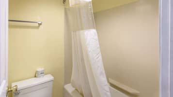 A bathroom with a toilet, a towel rack, and a shower curtain.