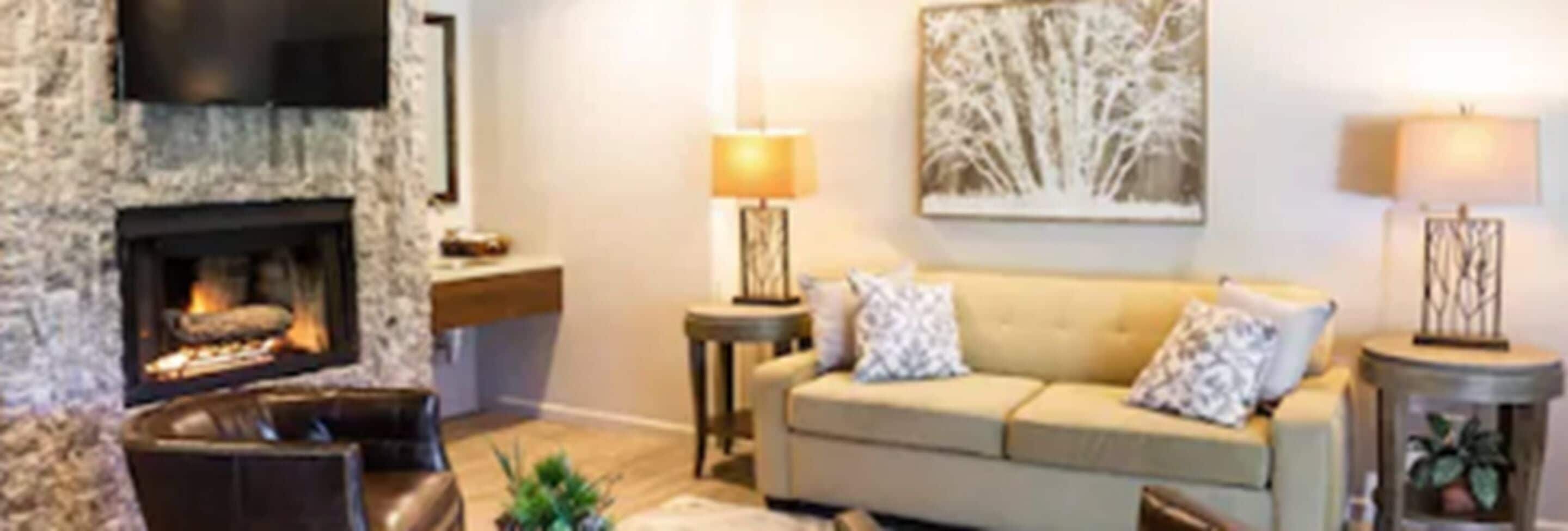 A living room with a fireplace, a sofa, a coffee table, and two lamps.
