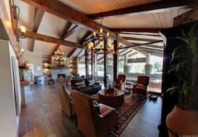 Amplia sala de estar con chimenea, asientos cómodos y vistas al exterior.