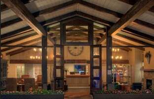 Un vestíbulo con techo de madera, un mostrador de recepción y una chimenea.