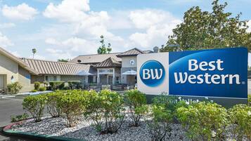 A Best Western hotel sign with a clear sky and a building in the background.