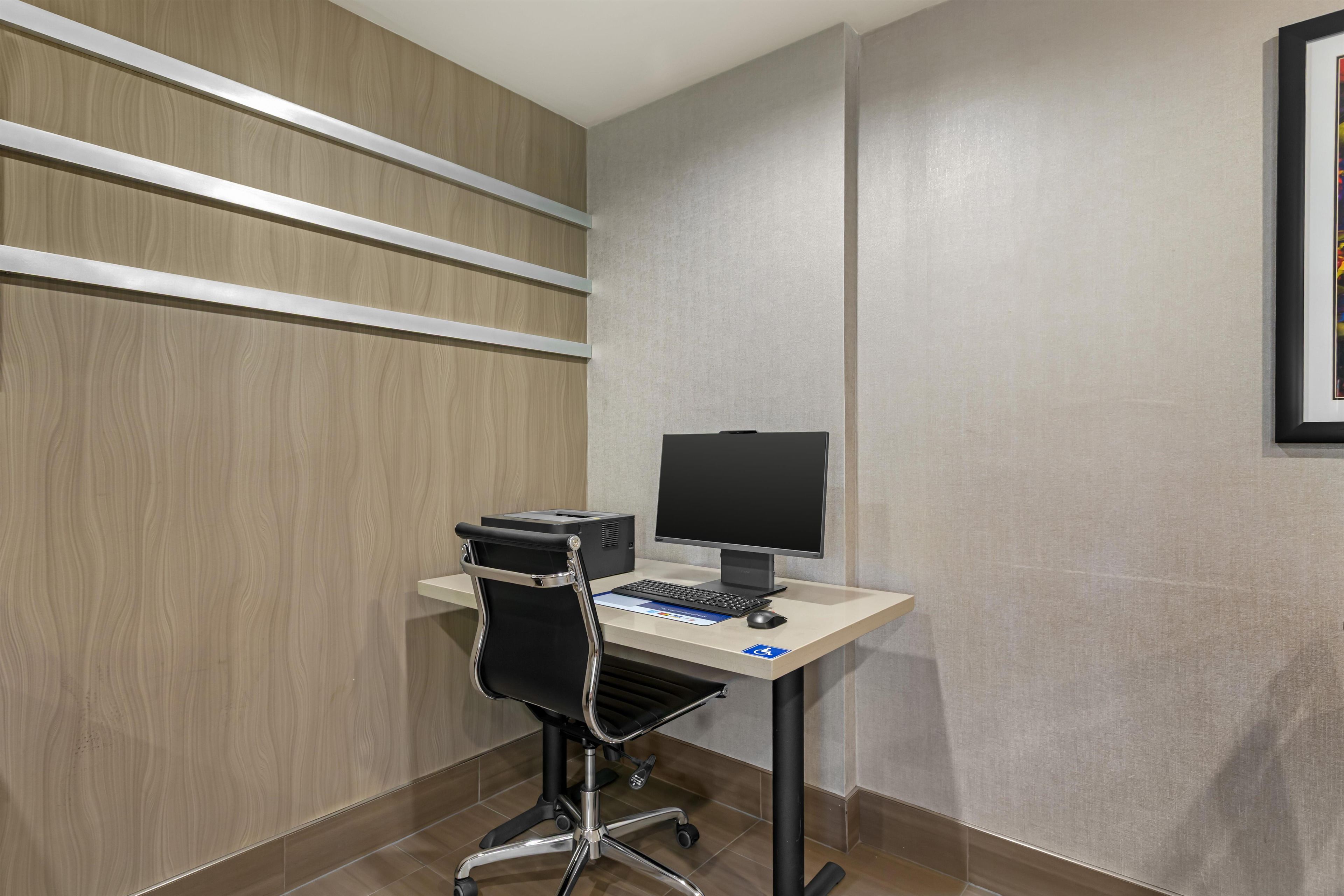 A modern office space with a desk, computer, and chair.
