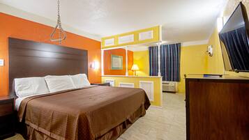 A hotel room with a bed, a desk, a television, and a bathroom.