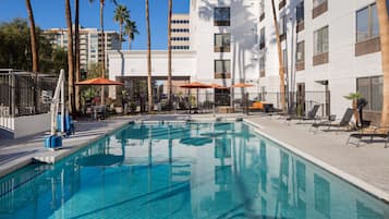 Una piscina al aire libre, tumbonas