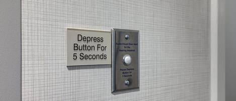 A depression button for 5 seconds on a textured wall.