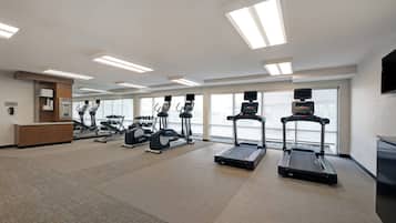 A gym with treadmills, elliptical machines, and weight equipment.